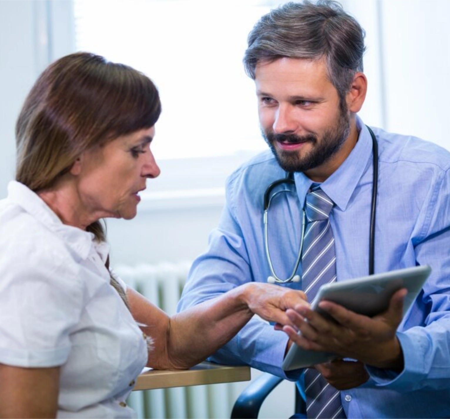 Doctor from clinic showing health report to patient through EHR